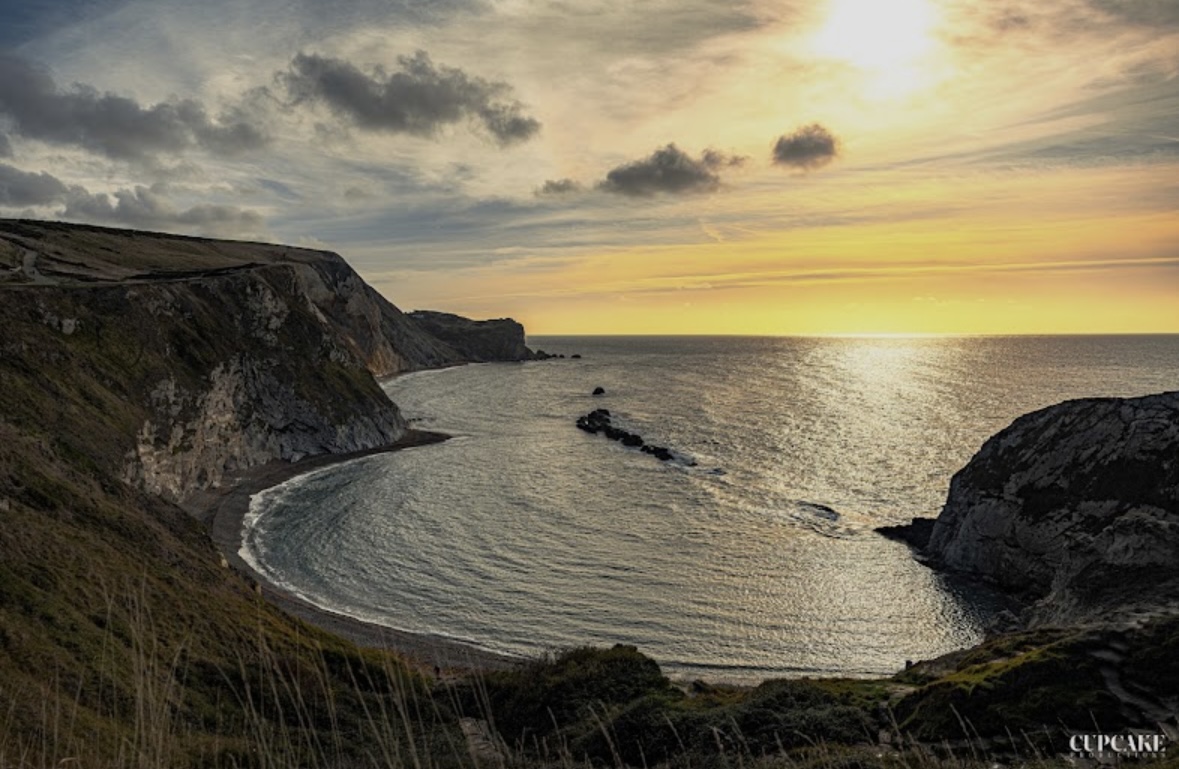 A dramatic coastal setting at sunset